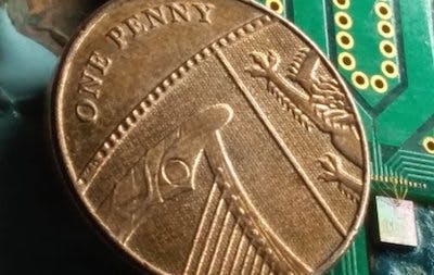 A chip-based device measuring a millimeter square can potentially generate quantum-based random numbers at gigabit-per-second speeds. The small square to the right of the penny contains all the optical components of the random-number generator.