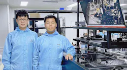 The team’s diamond Raman vortex laser experimental optical platform with Zhenxu Bai (left) and Hui Chen (right) of the paper. A physical image of the device is also shown on the right-hand monitor in the background.