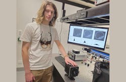 Ph.D. student Zane Peterkovic with a photon-counting camera; the screen behind displays the improvement in quality possible with camera optimization. Ph.D. student Zane Peterkovic with a photon-counting camera; the screen behind displays the improvement in quality possible with camera optimization.