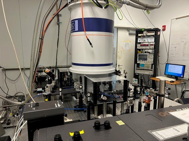 dramatic scientific photograph showing quantum measurement apparatus with laser beams and detection equipment