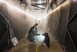 Image: Sandia National Laboratories developed a fog chamber to test optics, like security camera sensors, in a controlled environment. Sandia chemical engineer Andres Sanchez checks an instrument that measures the particle size and concentration of the fog in the chamber’s atmosphere. Image: Sandia National Laboratories developed a fog chamber to test optics, like security camera sensors, in a controlled environment. Sandia chemical engineer Andres Sanchez checks an instrument that measures the particle size and concentration of the fog in the chamber’s atmosphere.