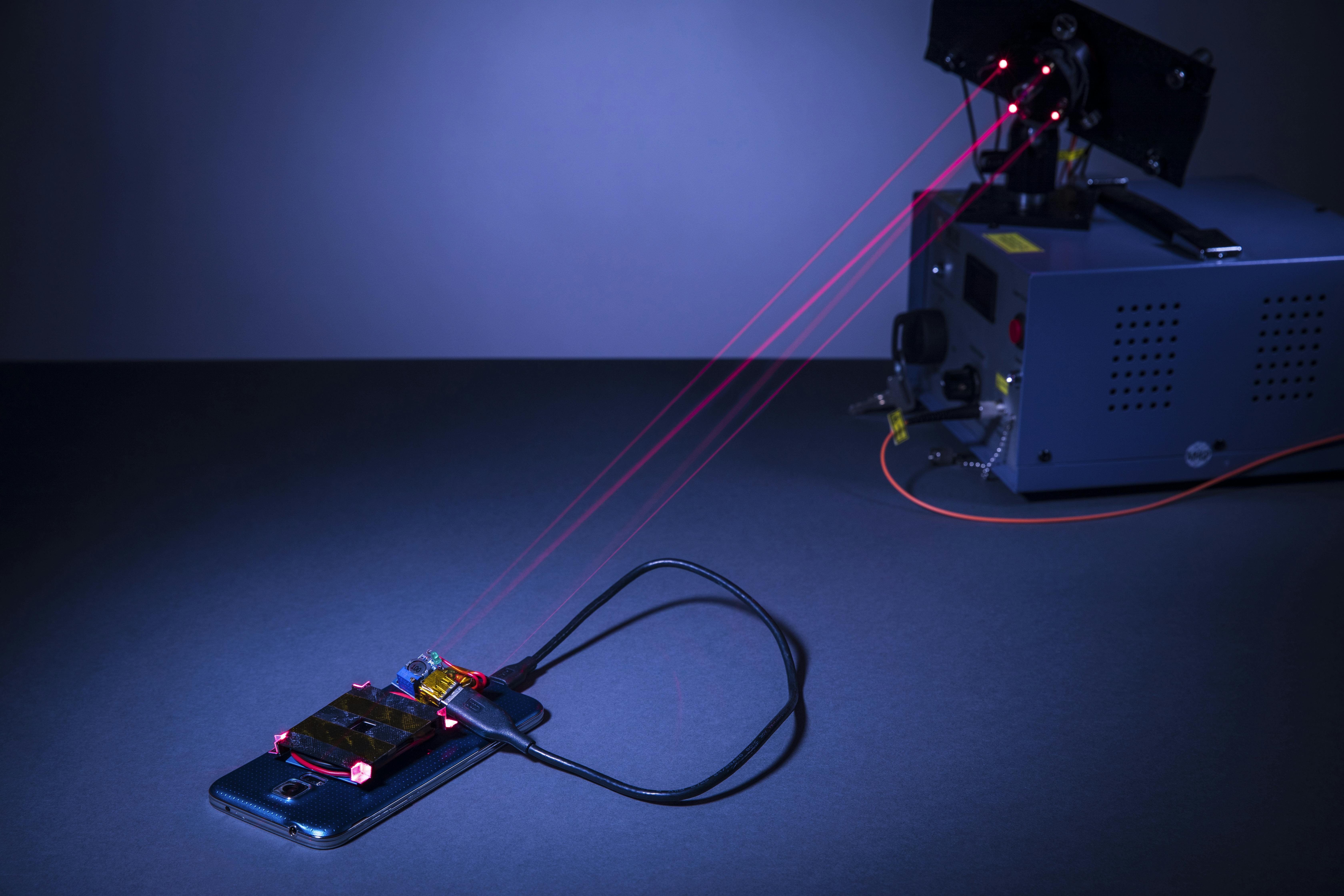 This laser-based wireless charging system was created by University of Washington engineers. The charging laser and guard lasers are normally invisible to the human eye, but red beams have been inserted here in place of the guard beams for demonstration purposes.