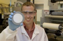 Matthew Hagedon of UC holds a sample of electrofluidic imaging film. The white plastic film, ten times thinner than a sheet of paper, is in a rigid frame for support during lamination into a display. The goal is to create a large roll of film that can be laminated onto electronics. Matthew Hagedon of UC holds a sample of electrofluidic imaging film. The white plastic film, ten times thinner than a sheet of paper, is in a rigid frame for support during lamination into a display. The goal is to create a large roll of film that can be laminated onto electronics.