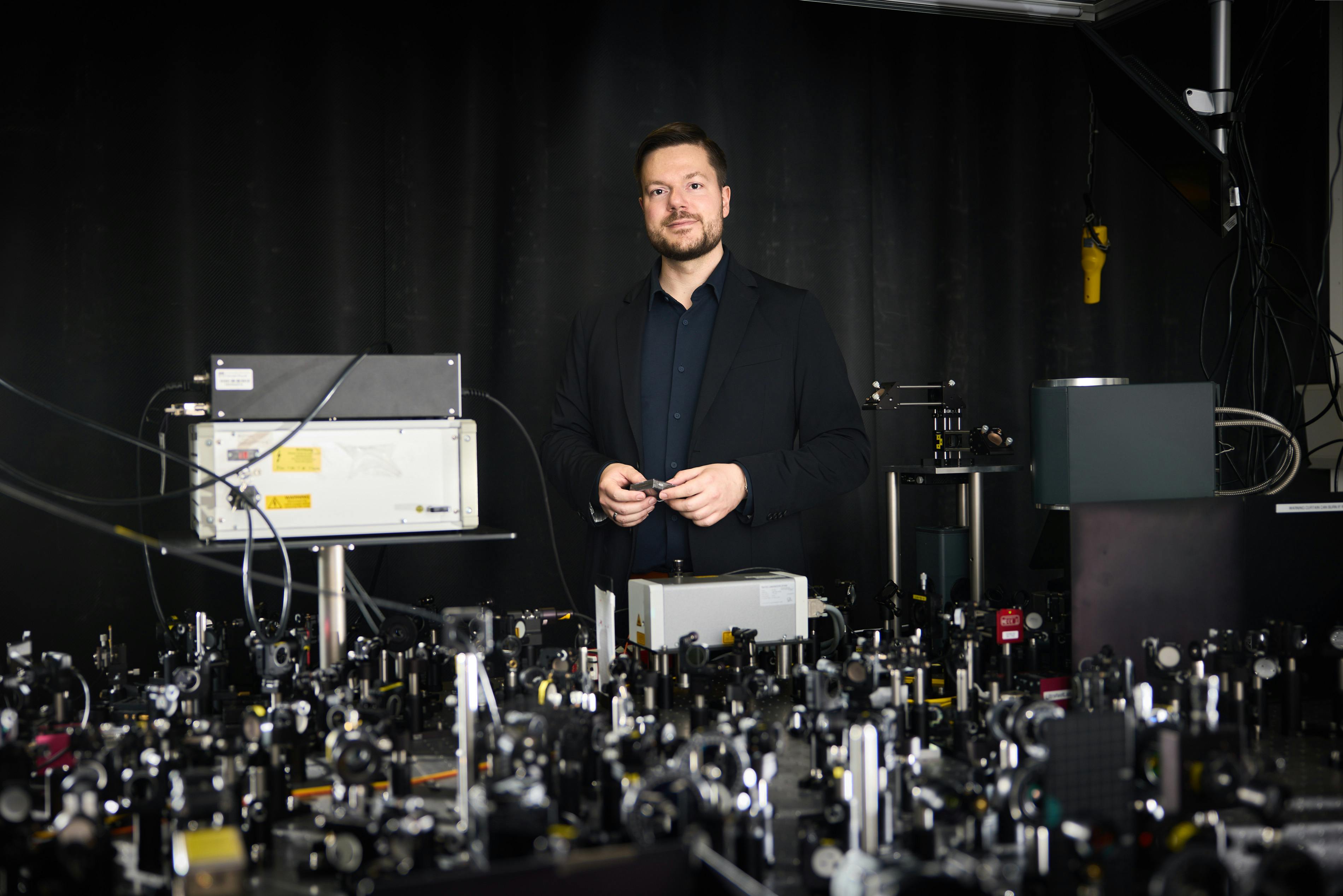 Professor Andreas Tittl in front of his lab&rsquo;s optical table. Credit: Stephan H&ouml;ck