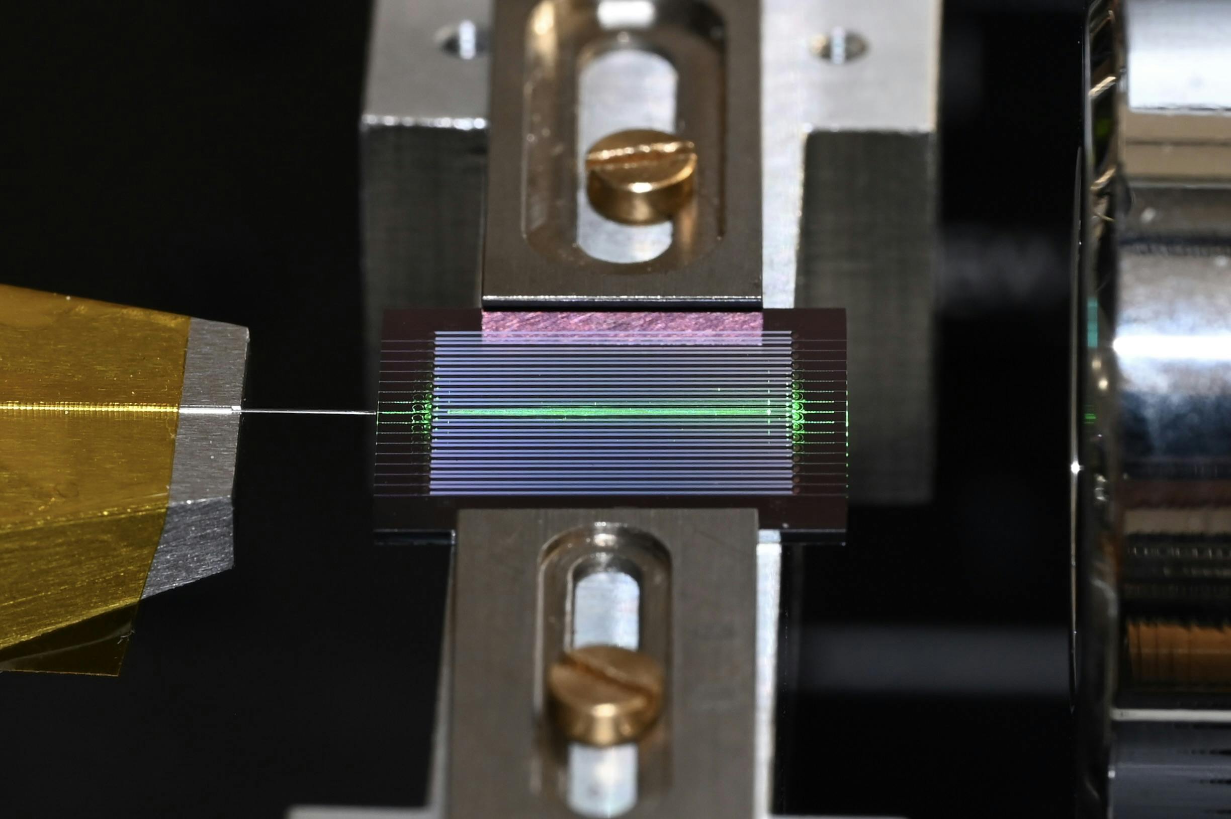 The team&rsquo;s experimental setup uses an on-chip optical parametric oscillator (OPO) to generate a frequency comb of laser-like light over a wide range of frequencies. An optical fiber is to the left and a free-space objective is to the right. Credit: Alireza Marandi