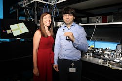FIGURE 1. Christina Beanea-Chelmus, head of EPFL’s Laboratory of Hybrid Photonics, with Yazan Lampert, who holds the team’s lithium niobate chip that generates and detects THz by converting them to and from ultrafast optical signals. FIGURE 1. Christina Beanea-Chelmus, head of EPFL’s Laboratory of Hybrid Photonics, with Yazan Lampert, who holds the team’s lithium niobate chip that generates and detects THz by converting them to and from ultrafast optical signals.