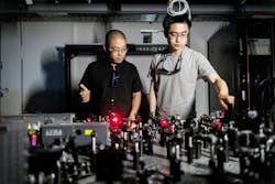 FIGURE 3. Bo Zhen (left) and Li He (right) in the lab with the team’s ultrafast laser setup. Credit: Eric Sucar/University of Pennsylvania FIGURE 3. Bo Zhen (left) and Li He (right) in the lab with the team’s ultrafast laser setup. Credit: Eric Sucar/University of Pennsylvania
