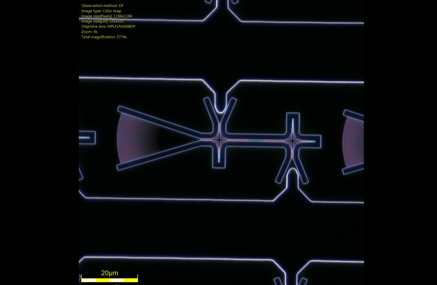 Dark-field microscope image of a diode nanocavity device with a grating coupler (left) for optical excitation/collection and electrical connections to the p-i-n diode (top/bottom). Credit: Michael Dobinson