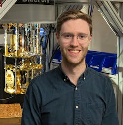 Michael Dobinson in the lab with one of the SQT lab’s cryostats open in the background. Credit: Felix Hugnagel Michael Dobinson in the lab with one of the SQT lab’s cryostats open in the background. Credit: Felix Hugnagel