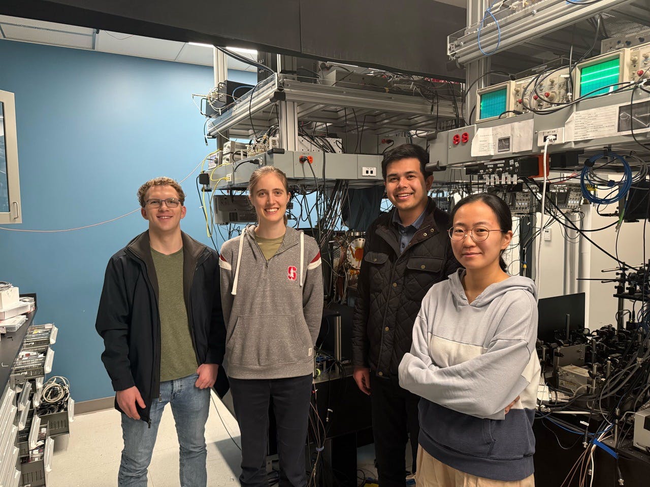 Adam Shaw, Anna Soper, Danial Shadmany, and Da Yeon Koh in front of the cavity array microscope apparatus.