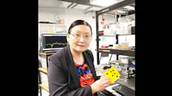 Professor Xiaoke Yi in the lab with her group’s AI nanophotonic chip prototype.