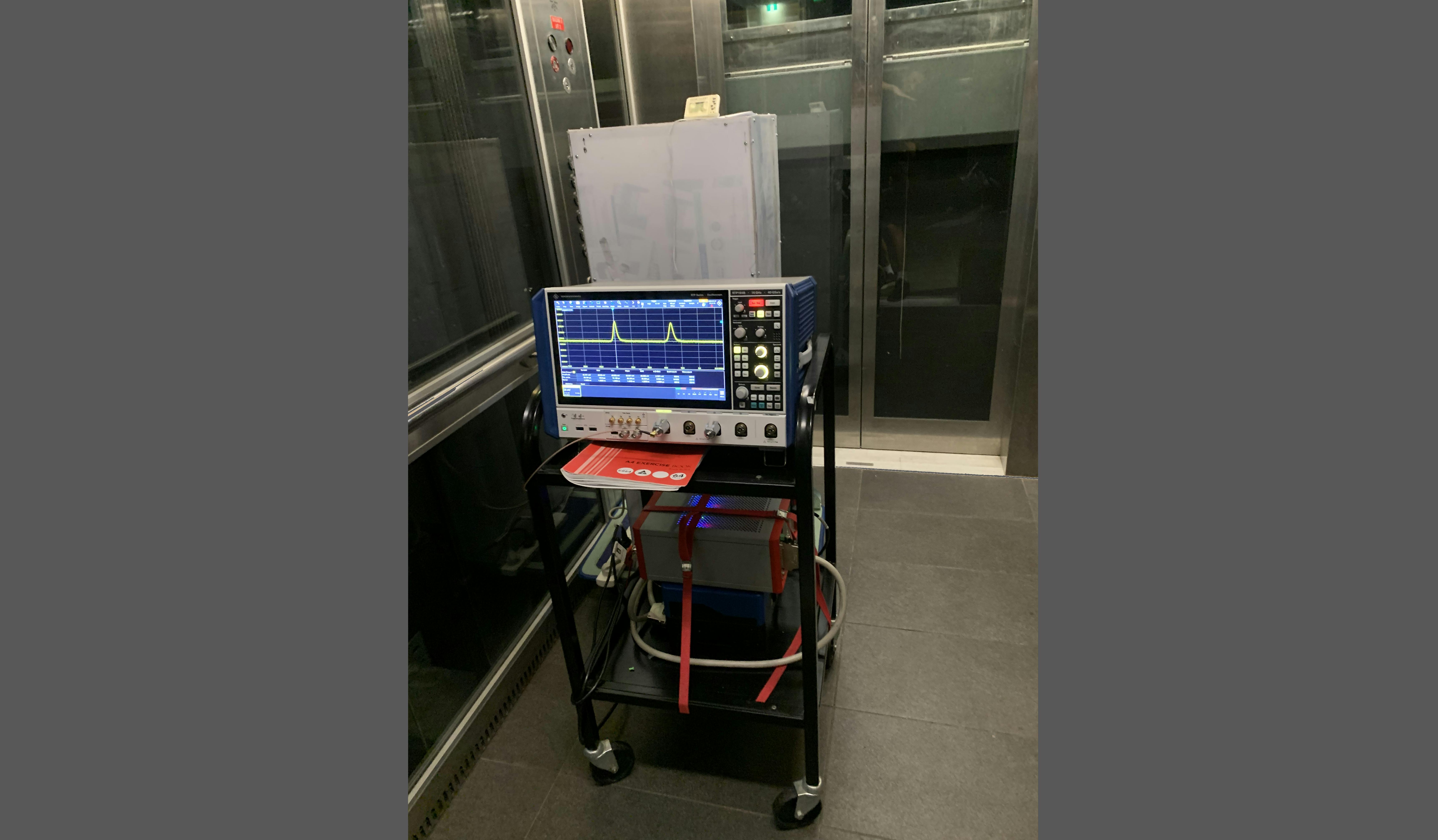 The team&rsquo;s experimental setup in an elevator: An optical fiber spool is kept within an enclosure for temperature control, while the white case insulates the optical fiber and all other fiber-optic components from the environment.