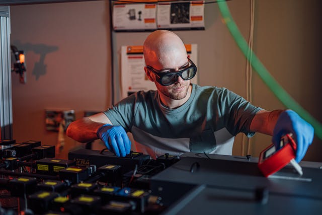 Pierre Luc Th&eacute;riault, a Ph.D. student in engineering physics, aligns the team&rsquo;s experimental setup.