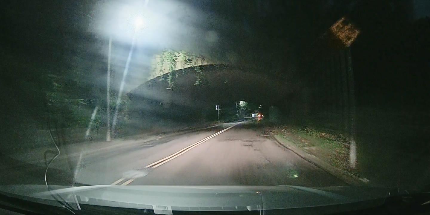Conventional CMOS automotive camera with in-camera HDR shows significant motion blur on a road sign.