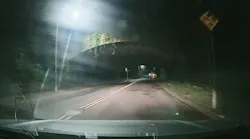 Conventional CMOS automotive camera with in-camera HDR shows significant motion blur on a road sign.